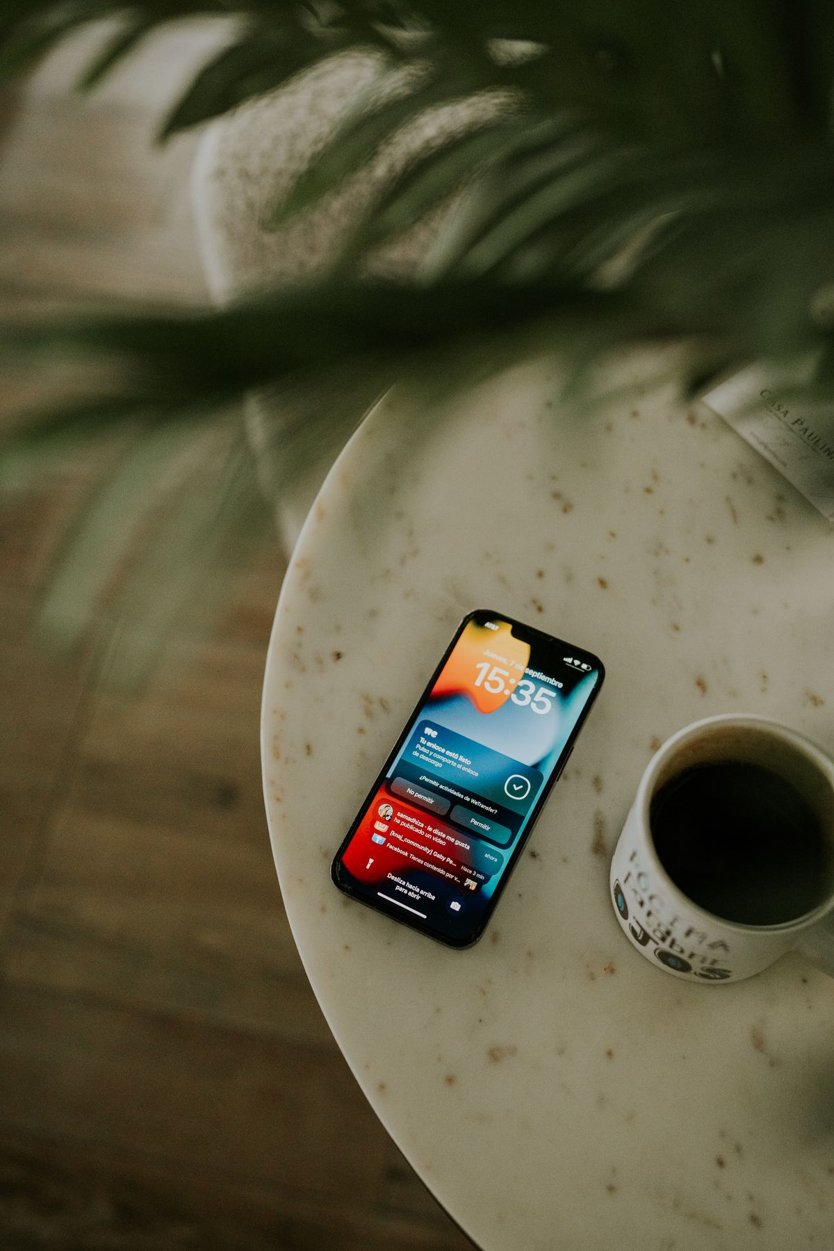 コーヒーのあるテーブルに置かれたスマートフォン
